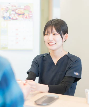 笑顔で患者さんと話す歯科衛生士